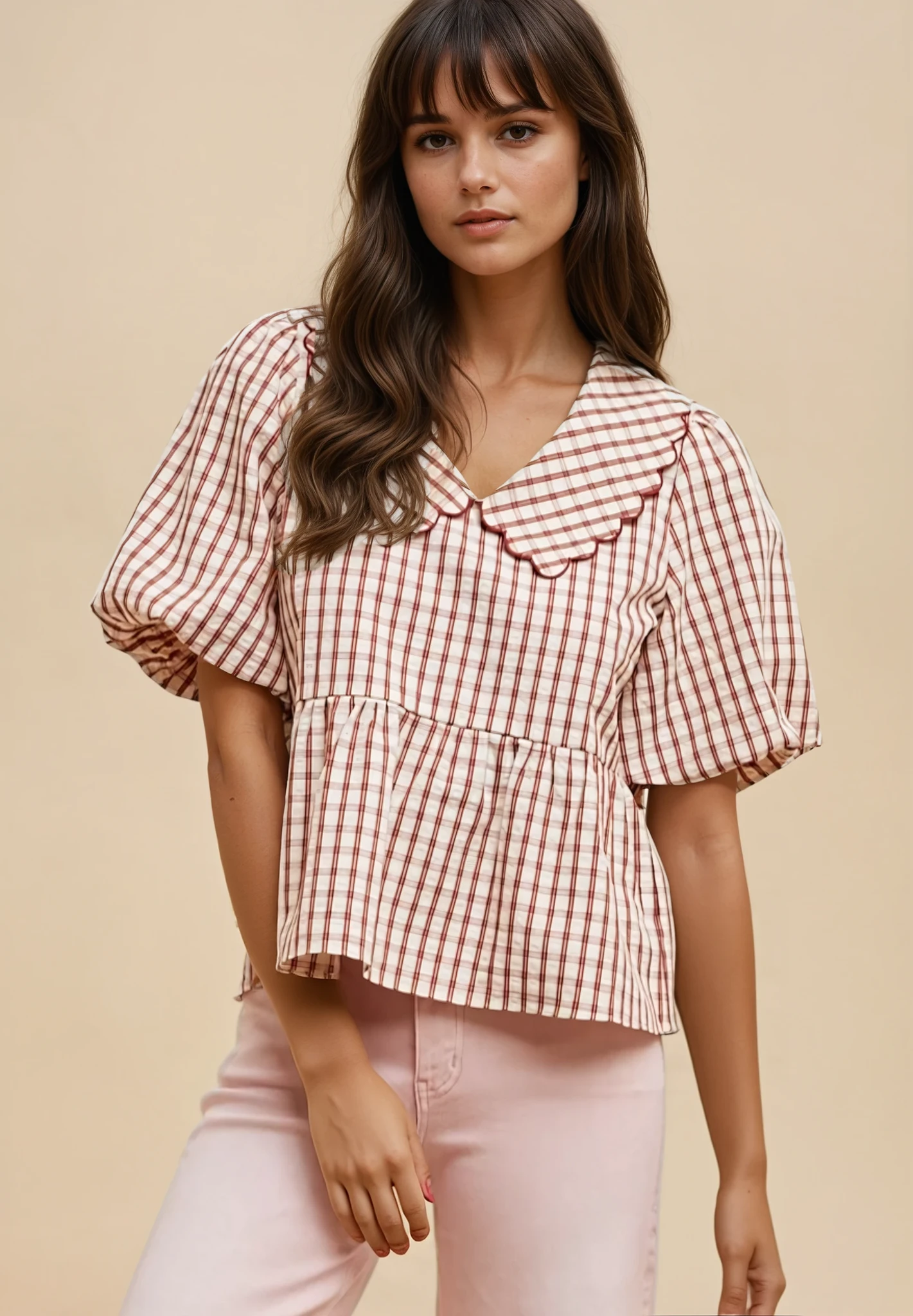 Woman wearing a red and white checkered blouse with pink pants on a beige background