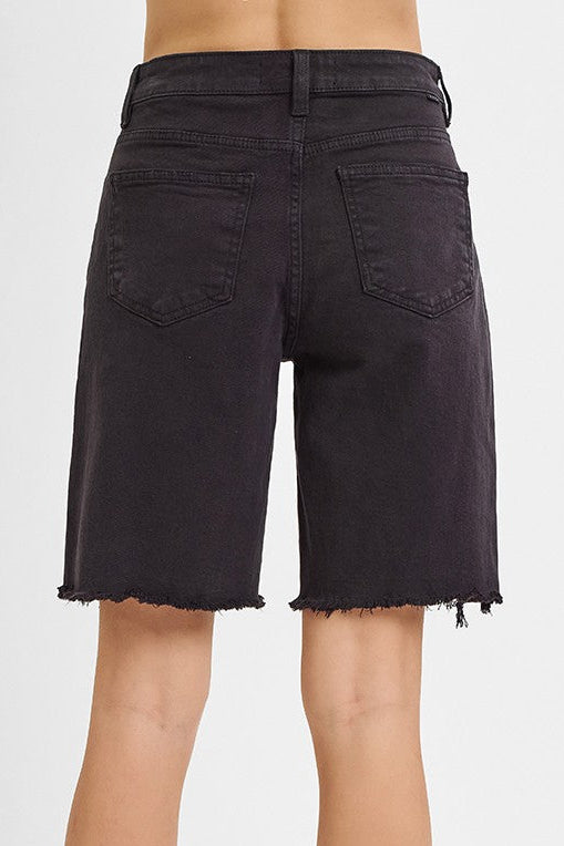Black denim shorts worn by a person on a white background