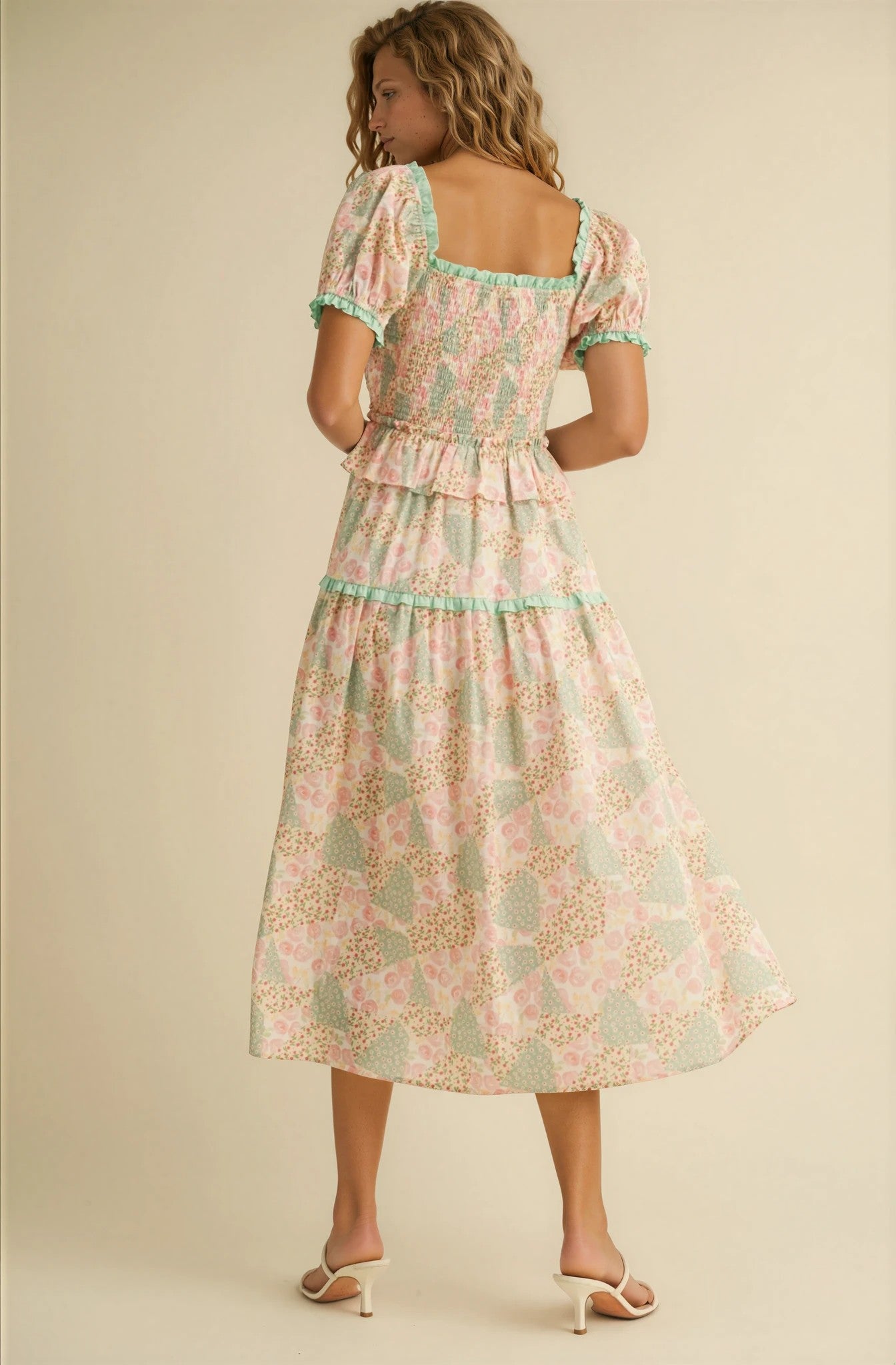 Woman wearing a floral dress with a beige background