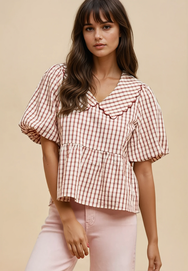 Woman wearing a red and white checkered blouse with pink pants on a beige background