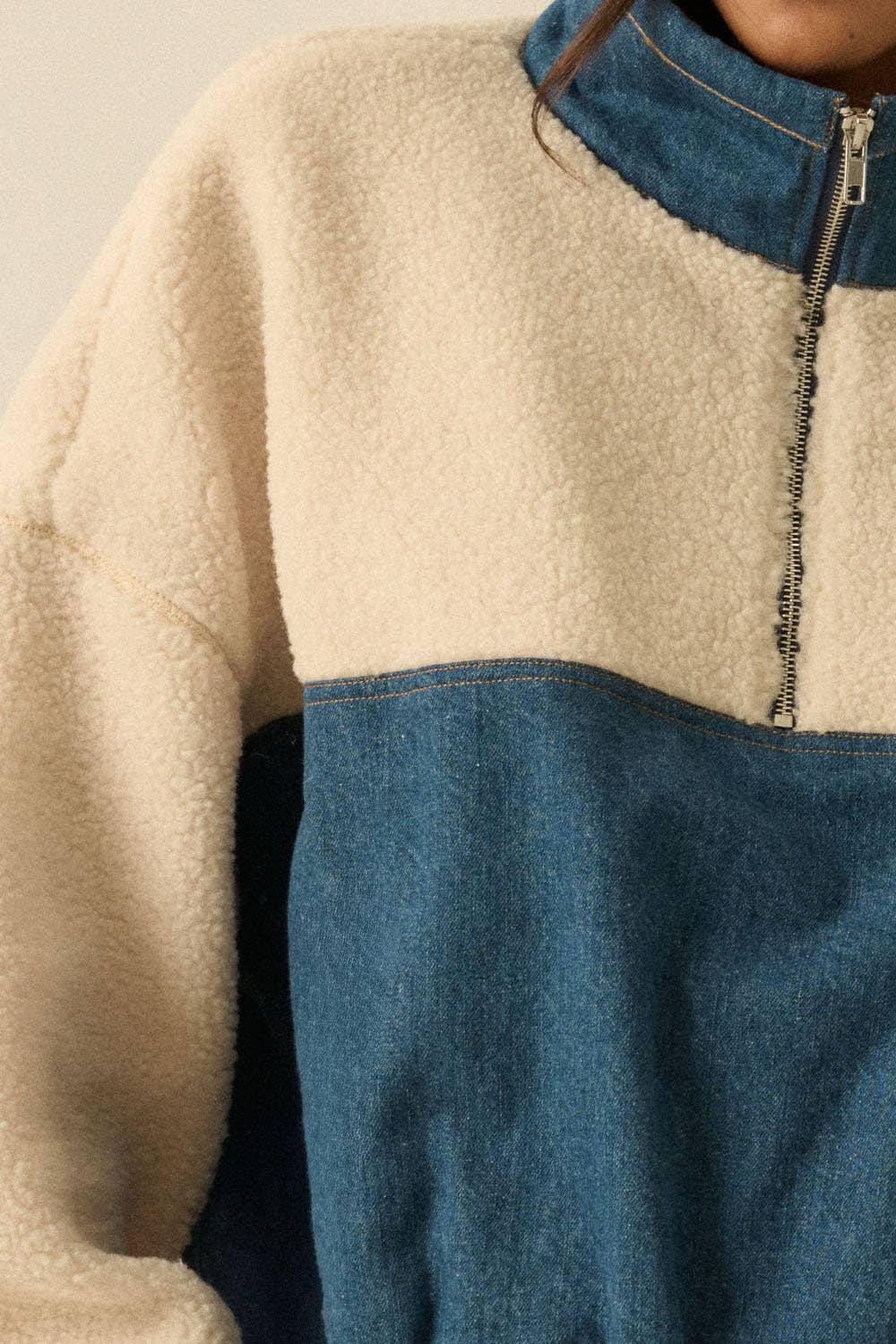 Close-up of a two-tone fleece jacket with beige and blue colors.